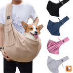 Man carrying beige crossbody pet sling with happy Corgi inside outdoors