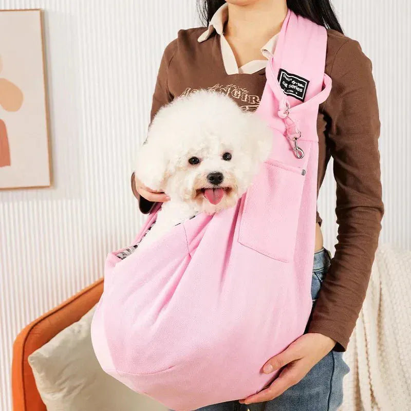 Army green sling carrier worn by woman walking small dog in park