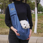 Front pocket of blue sling carrier holding keys and smartphone