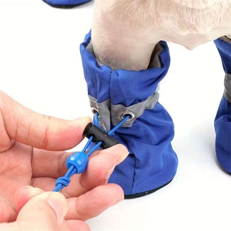 Royal blue waterproof dog boots with gray reflective strip shown on small dog paw